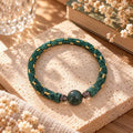 Forest green hand-braided bracelet with gold-tone accents and three front beads